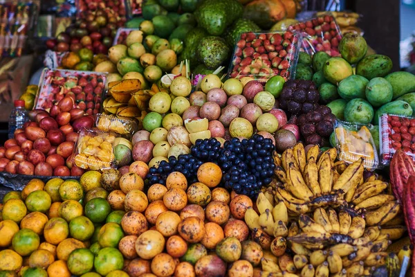 Asian exotic fruits. Market stall with variety of organic fruits. Colorful fruits in the marketplace. Bright summer background. Healthy, organic food. Natural nutrition for diet. Selective focus.
