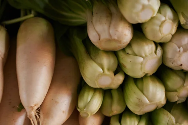 Fresh vegetables in local asian market. Home grown vegetable in local market. Organic bock chou and radish for sale at an asian market. Selective focus.