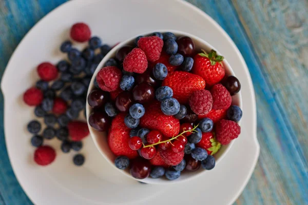 Modern bir İtalyan restoranında mavi bir vintage tarzı üzerinde çeşitli olgun çilek berry tatlı servis