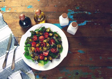 Ev kadını hazırlamak salata domates ve bıldırcın yumurtası ve parmesan peyniri, keten havluda yalan tüm güzel çatal ile servis sıcak aperatifler