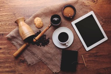 Bir ışık ahşap geçerli telefon ve tablet, güçlü siyah kahve, kurabiye iki tür bir kupa