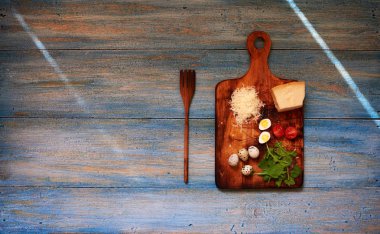Bir ahşap eski püskü retro bir ahşap tahta kesme sebze üzerine Parmesan peyniri, bıldırcın yumurtası ve kiraz domates, büyük ahşap çatal yakınındaki bir parçasıdır geçerli
