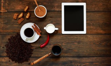 Ahşap masa üzerinde üstten görünüm beyaz tablet bilgisayar boş siyah perde reklam görüntülemek için veya başka bir fincan sıcak kahve, Türk pot cezve, kahve çekirdekleri ile app tasarım. Vintage tarzı.