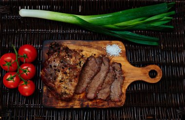 Tek parça, sonraki pırasa ve hangi aşçı taze hafif salata dan kiraz domates fırında domuz eti bonfile hizmet eden bir rattan tahta masa yalanlar üzerine pişmiş