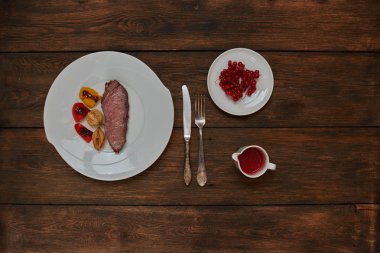 Pişirmek trendy steakhouse kuzu ızgara, pişmiş tatlı ve ekşi berry soslu bonfile döktü bir beyaz tabak svehru üzerinde hizmet