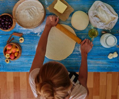 Kız sarışın apronda börek için puf böreği rulo. Cook kek Ekmek hamuru ve meyve içmesine krema ilavesi ile yapar