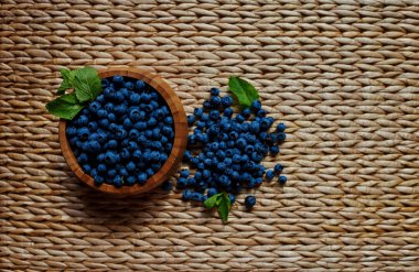 Kahverengi ahşap duvar arka planı bir ışık ahşap kase taze yaban mersini, gelen satın alma bir ev hanımı bir tatlı hale getirecek