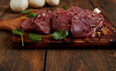 Koyu ahşap rustik arka plan üzerinde yemek pişirmek için malzemelerle taze et kadar kapatın. 