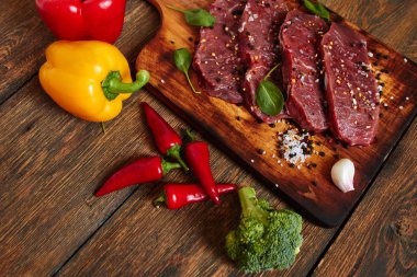 Ham antrikot Biftek Biftek kesme tahtası üzerinde malzemelerle yemek. Organik ham sığır. 