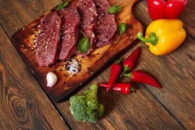 Ham sığır filetosu biftek baharat sebze ahşap arka plan üzerinde tarih ile. Biber biber, ot, tuz ve karabiber.