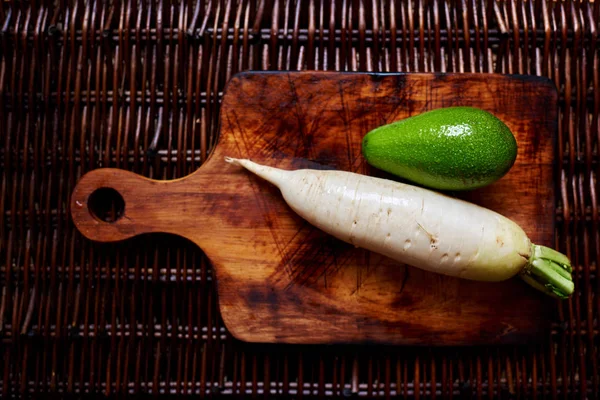 Horseradish and avocado on the vintage table, creative picture of fresh veggies