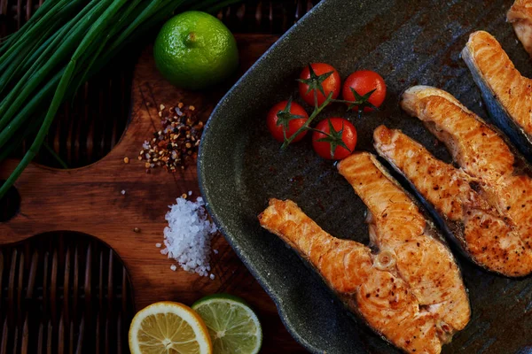 Fırında somon taze sebzelerle servis edilir.