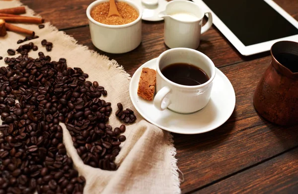 クッキーに近い受け皿に新鮮なブラック コーヒーの白いカップでオフィスでテーブルのバック グラウンド プレートに見られる — ストック写真