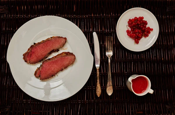 İki aşçılar hızlı bir şekilde bir tavada, sos domates ve sıcak biber yapılmış yüksek ateşte ızgara pirzola domuz eti bonfile hazırlamak