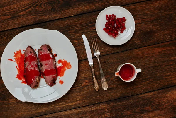 Kızarmış hızlı yangında, sosu yanında duran karanlık dokusal meşe masada yemek sığır eti iki adet beyaz bir tabağa hizmet veren