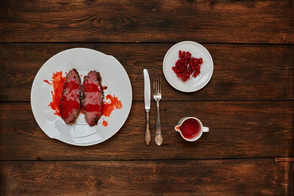 Kızarmış hızlı yangında, sosu yanında duran karanlık dokusal meşe masada yemek sığır eti iki adet beyaz bir tabağa hizmet veren