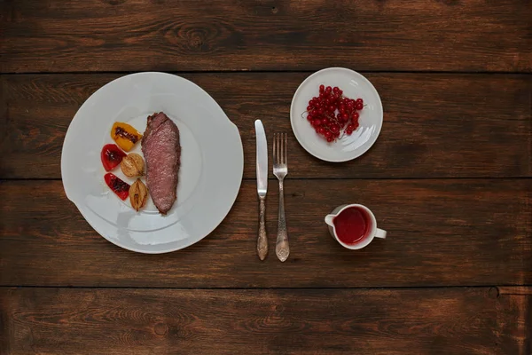 Pişirmek trendy steakhouse kuzu ızgara, pişmiş tatlı ve ekşi berry soslu bonfile döktü bir beyaz tabak svehru üzerinde hizmet