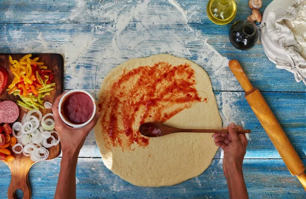 厨师手正在将巴氏杀菌番茄酱撒到比萨基地 原意大利原始比萨 传统风格的准备 食品烹饪理念 顶级景观 质朴风格 食品背景 — 图库照片