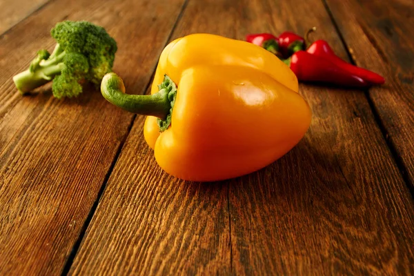 Organic foods. Yellow sweet bell pepper, red chilli and cauliflower on  rustic table.  Healthy meal and vegetarian concept. Ingredients for cooking healthy eating. Food background with copy space