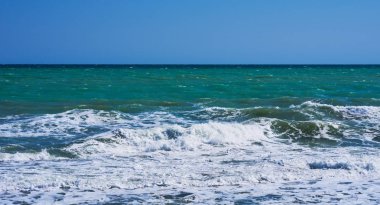 Bir koy ve kaya sualtı ile Kayalık kıyı şeridi, su yüzeyinin üzerinde bölünmüş görünümü, Akdeniz, İspanya. Masmavi deniz, dalga ve mavi gökyüzü. Deniz ufku ve berrak derin mavi gökyüzü ile Seascape.