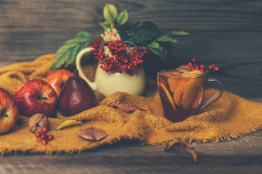 Sonbahar yaprakları ve ahşap masa üzerinde elma çayı fincan. Sonbahar ruh hali arka plan.