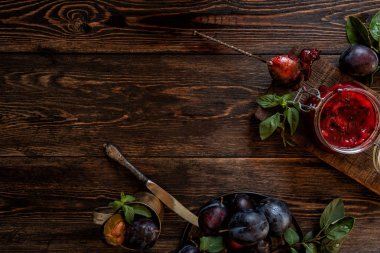 Tabakta taze organik erik ve rustik arka plan üzerinde cam bir kavanozda reçel. Autnum hasadı. Kopyalama alanı.