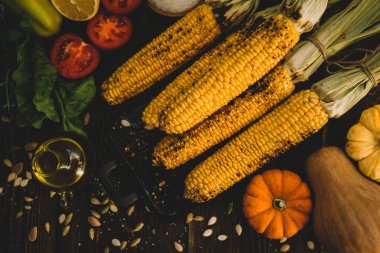 Mısır koyu rustik arka plan üzerinde peynir ve baharat ile ızgara. Sonbahar yemek arka plan. Yaz veya sonbaharda fast food. Tonlu görüntü. Üstte görüntü.