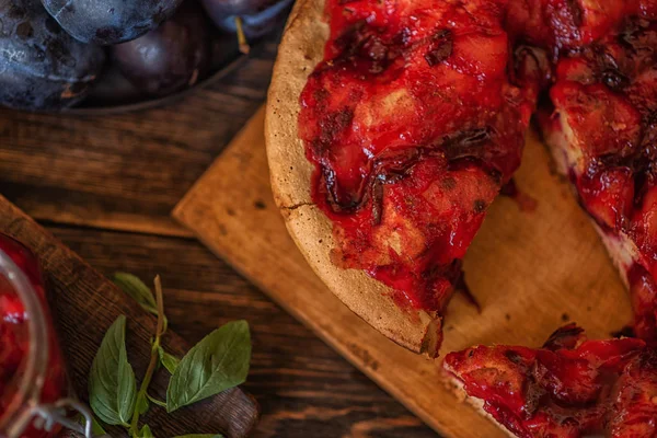 Fruit pie. Sweet pie, tart with fresh plums. Delicious cake with plums. Fall harvest concept. Fresh plums with leaves. Healthy, organic food. Toned image.