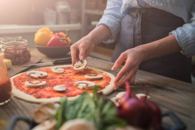 Pizza sanatı. Pizza yapma süreci. Masada malzemeler ve baharatlar ile pizza için çiğ hamur. Koyu ahşap arka planda geleneksel İtalyan pizza ve sebzeleri. Pizza menüsü. Yumuşak odaklama.