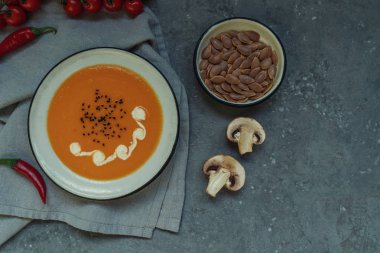 Sonbahar sebze ve kabak çekirdeği ile bir kapta kabak çorbası. Vegan çorbası. Sebze krema çorbası ve malzemeler. Üst te. Sağlıklı beslenme veya vejetaryen gıda kavramı. Kopyalama alanı ile üstte görünüm.