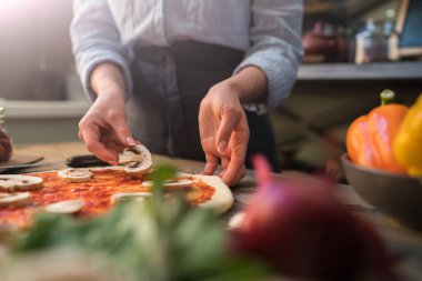 Pizza sanatı. Pizza yapma süreci. Masada malzemeler ve baharatlar ile pizza için çiğ hamur. Koyu ahşap arka planda geleneksel İtalyan pizza ve sebzeleri. Pizza menüsü. Yumuşak odaklama.