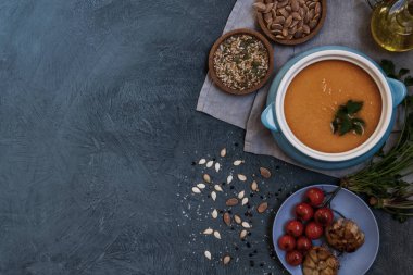 Gri arka plan üzerinde krem ve kabak çekirdeği ile kabak organik çorba Kase. Diyet vejetaryen yemek. Sağlıklı beslenme gıda kavramı. Ev yapımı sonbahar çorbası. Kopyalama alanı ile üst görünüm. Tonlu görüntü.