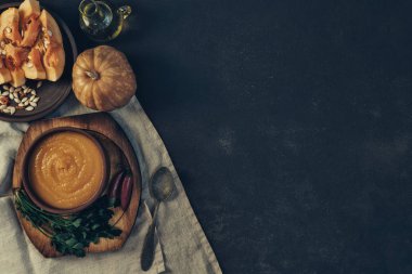 Sonbahar sebze ve kabak çekirdeği ile bir kapta kabak çorbası. Vegan çorbası. Sebze krema çorbası ve malzemeler. Sağlıklı beslenme veya vejetaryen gıda kavramı. Kopyalama alanı ile üst görünüm. Tonlu görüntü.