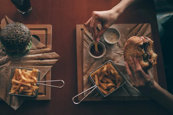 Kadın Patates Kızartması Ile Burger Cafe Arka Plan Üzerinde Tutar — Stok fotoğraf