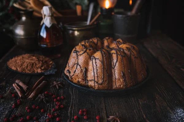 在质朴的家庭厨房 木桌上摆着带浆果 香料和巧克力的节日蛋糕 圣诞烘焙背景 在深色木制背景上烹饪的食材 自制节日食品 色调图像 — 图库照片
