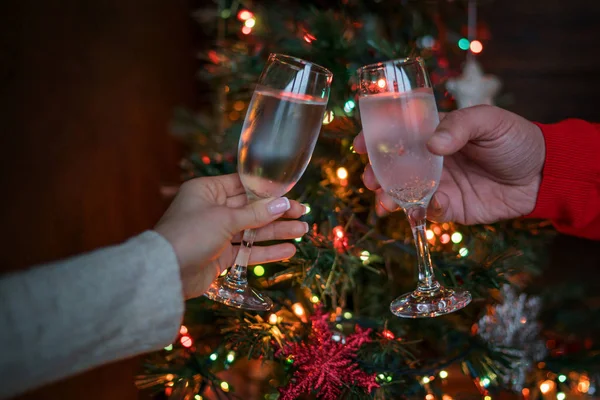 Two Glasses Champagne Raised Toast Christmas Tree Glowing Lights Holiday — Stock Photo, Image