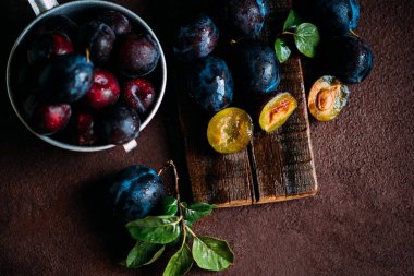 Bahçe erikleri masada. Yaprakları ile taze erik kapatın. Erik yaz veya sonbahar hasadı. Tonlu görüntü. Seçici odaklama.