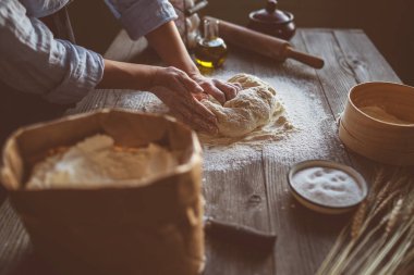 Kız elleri koyu ahşap masa üzerinde un ile oklava tutmak. Pişirme arka plan, metin, meru, tarifi için boşluk kopyalamak. Gıda konsepti. Seçici odaklama.