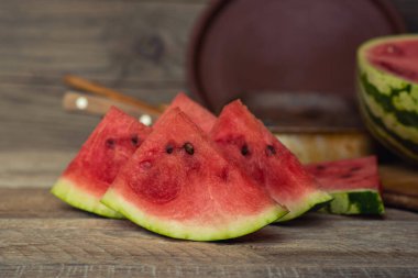 Rustik vintage arka planda parlak sulu karpuz. Yarım ferahlatıcı çilek üst görünüm ve yumuşak odak. Yaz aylarında sağlıklı beslenme ve vejetaryen yemekler. Tonda vintage görüntü.