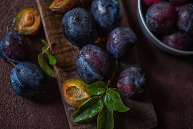 Koyu ahşap bir arka plan üzerinde damla erik. Tonlama. Seçici odaklama.