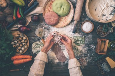 Pişirme ev yapımı makarna yapma süreci. Şef taze İtalyan geleneksel makarna yapmak. Düz yatıyordu. Üst te. Çerçeve. Rustik stil, tonlu görüntü.