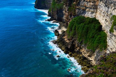 Büyük dalgalar ve güzel kayalar ile Bali deniz manzarası. Deniz plajı doğa, açık Endonezya. Ada manzarası. Okyanus sahilinde yaz tatilleri. Endonezya plajda seyahat tatil.