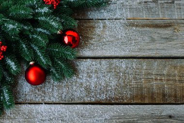 Ahşap tahta üzerinde Noel ağacı dalları, dekorasyon ve kırmızı topları ile tebrik kartı için Noel arka plan. Metin için kopyalama alanı ile üst görünüm.