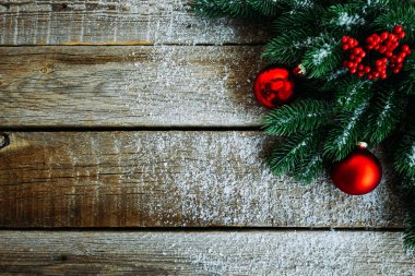 Ahşap tahta üzerinde Noel ağacı dalları, dekorasyon ve kırmızı topları ile tebrik kartı için Noel arka plan. Metin için kopyalama alanı ile üst görünüm.
