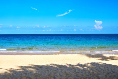 Kumlu sahilde yumuşak bir mavi okyanus dalgası. Arkaplan.