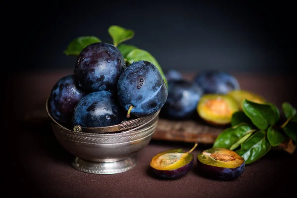 Bowl with ripe juicy plums on table. Fresh organic plums. Summer harvest. Autumn harvest. Beautiful still life. Toned image. Selective focus.