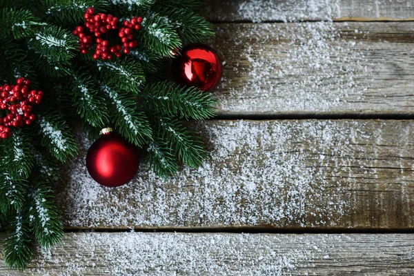 クリスマスツリーの枝 装飾や赤いボールとグリーティングカードのためのクリスマスの背景は 木製のボード上 テキストのコピースペースを含むトップ ビュー — ストック写真