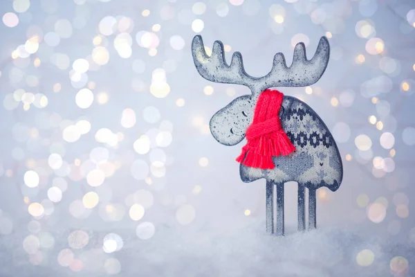 抽象的なきらめくライトの背景 ヴィンテージフィルター ソフトフォーカスのクリスマスの装飾 ぼやけた光の背景に雪の上に赤いニットのスカーフを持つ木製の鹿 テキストのスペースをコピーする — ストック写真
