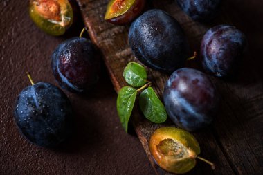 Koyu ahşap bir arka plan üzerinde damla erik. Tonlama. Seçici odaklama.