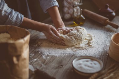 Eller pizza yapımı için hamur yoğurun. Ahşap tahtada pizza veya ekmek pişirme için taze çiğ hamur.